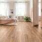 Spacious and bright bedroom interior with beige decorations, hardwood floor and a book on the window sill seat
